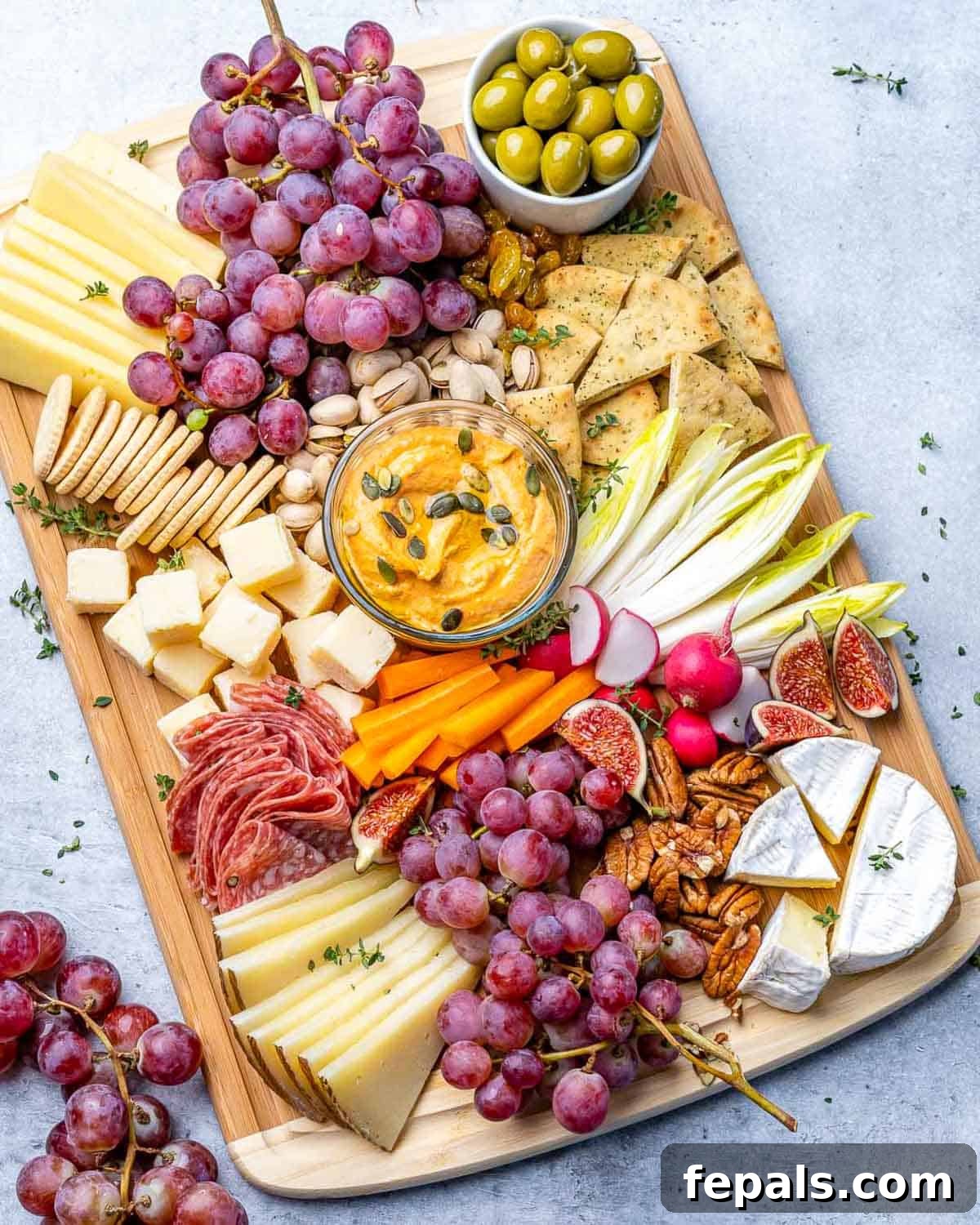 A Symphony of Flavors Fruit and Cheese 2 A beautifully arranged wooden platter featuring an assortment of nuts, fresh fruits like grapes and figs, and a variety of cheeses.