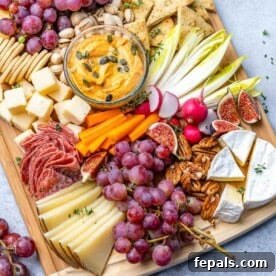 A vibrant fruit and cheese platter set up on a rustic cutting board, ready to serve.