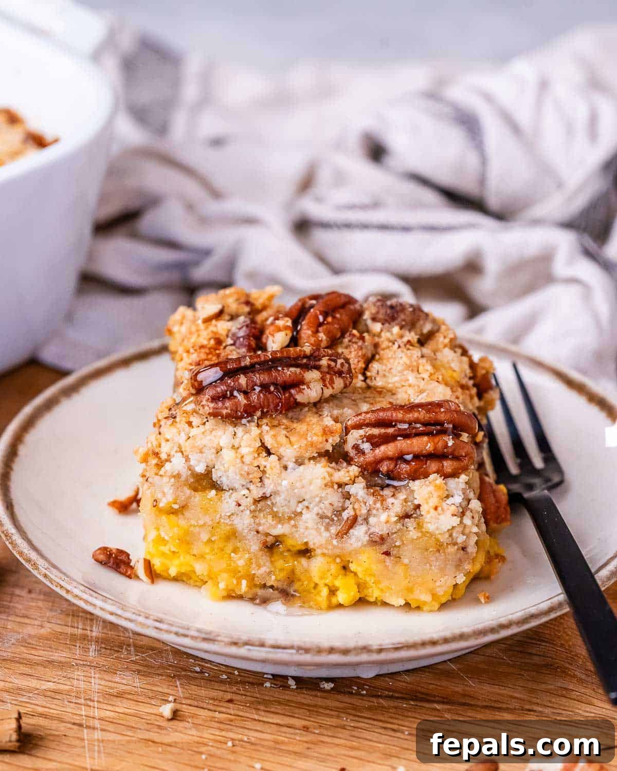 Gluten Free Pumpkin Dump Cake 7 A slice of gluten-free pumpkin dump cake on a white plate with a fork
