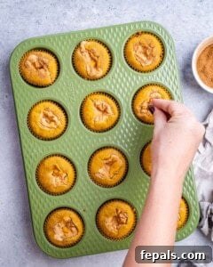 Spiced Pumpkin Cream Cheese Swirl Muffins 12 Sprinkling additional cinnamon sugar over warm pumpkin muffins still in the pan, fresh out of the oven.