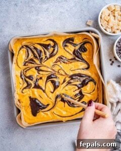 hand holding chopsticks to make swirls on brownies.