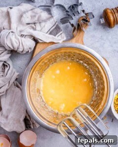 Spooktacularly Easy Halloween Cookies Kids Will Love 11 egg batter mixed in a bowl with an electric mixer for cookies.