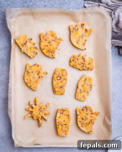 Spooktacularly Easy Halloween Cookies Kids Will Love 14 shaped cookie dough on a sheet pan.