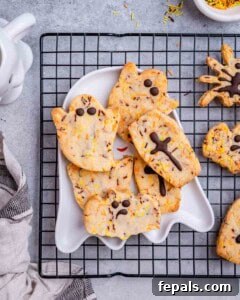 Spooktacularly Easy Halloween Cookies Kids Will Love 15 cookies on a plate over a cooling rack.