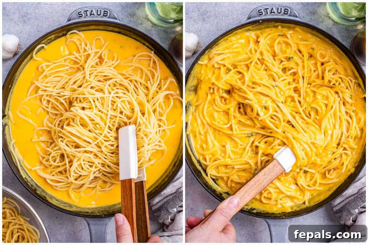 Simple Comfort Pumpkin Alfredo 6 Cooked fettuccine pasta being tossed and coated with the vibrant orange creamy pumpkin sauce in a large skillet, ready to be served.
