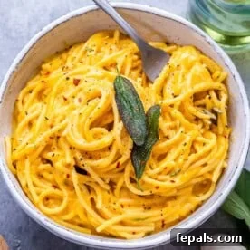 Simple Comfort Pumpkin Alfredo 7 A round bowl of pumpkin spaghetti topped with fresh green herbs, capturing the essence of a warm and inviting fall meal.