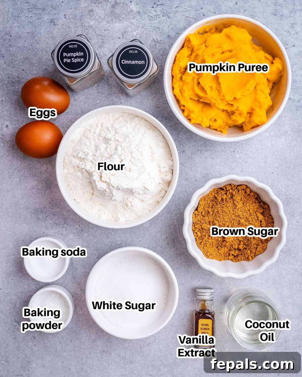 A flat lay of ingredients laid out to make pumpkin donuts, including pumpkin puree, eggs, flour, and spices.