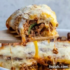 A tantalizing slice of zucchini lasagna being carefully lifted from a bubbling casserole dish, showcasing perfectly layered zucchini, rich meat sauce, and melted cheese.