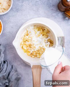 Savory Butternut Squash & Beef Ragu Pasta 12 Mixing milk into shredded cheese and sautéed onions in a saucepan to make the creamy sauce.