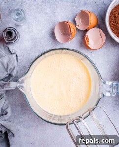 Mixing bowl with wet ingredients blended until creamy, ready for cocoa powder to be added.