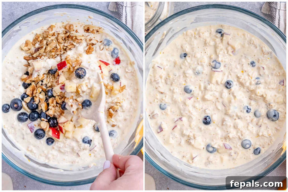 A process shot showing lemon-coated chopped apples, soaked overnight oats, Greek yogurt, and blueberries being combined in a large mixing bowl.