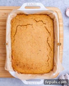 Golden Gluten Free Sweet Potato Cornbread 16 A full baking dish of golden-brown sweet potato cornbread just out of the oven, still warm and slightly cracked on top.