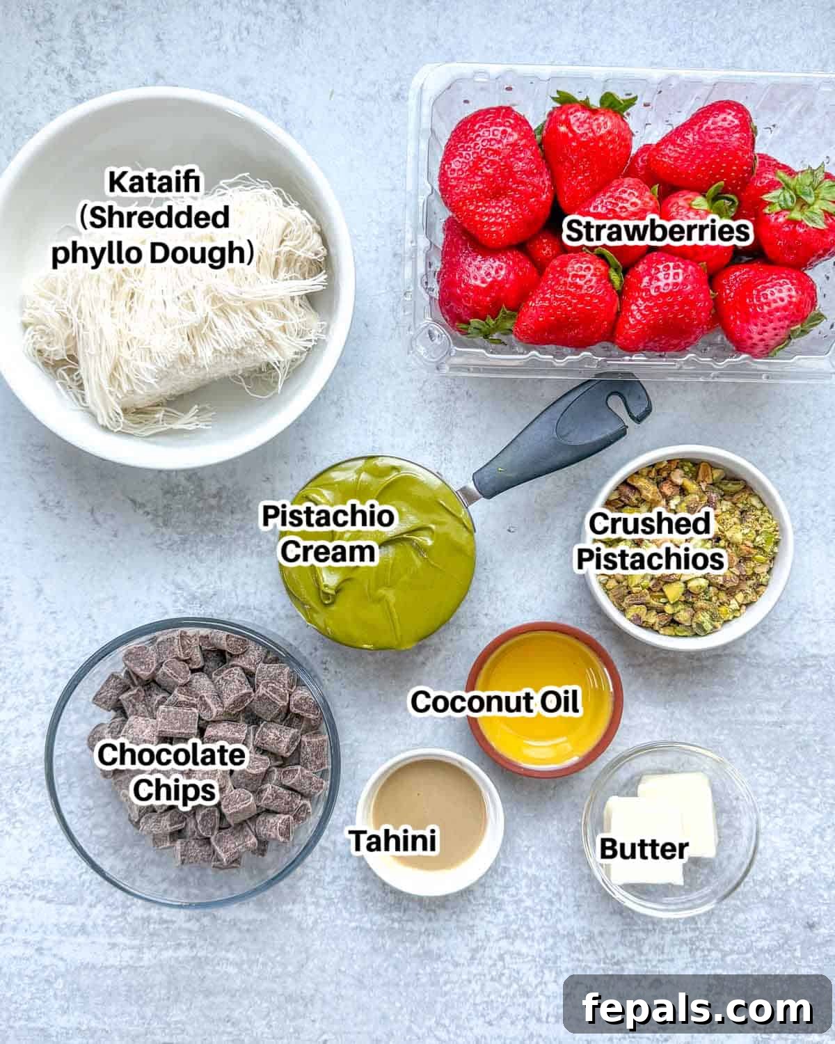 Viral Dubai Chocolate Strawberry Sensation 11 A flat lay image displaying all the essential ingredients needed to prepare the delicious Dubai Chocolate Strawberry Cups: fresh strawberries, butter, tahini, kataifi, pistachio cream, crushed pistachios, semi-sweet chocolate chips, and coconut oil.