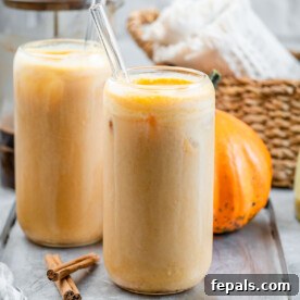 Two elegant glasses of pumpkin cream cold brew, each with a glass straw, invitingly presented for a refreshing fall beverage.