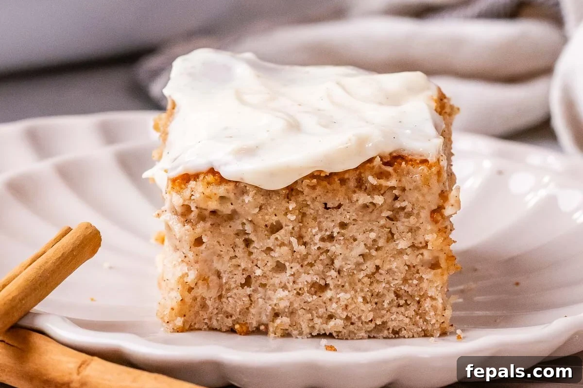 Cinnamon Swirl Dream Cake 2 A delectable slice of cinnamon roll cake served on a pristine white plate, showcasing its signature swirl and creamy glaze.