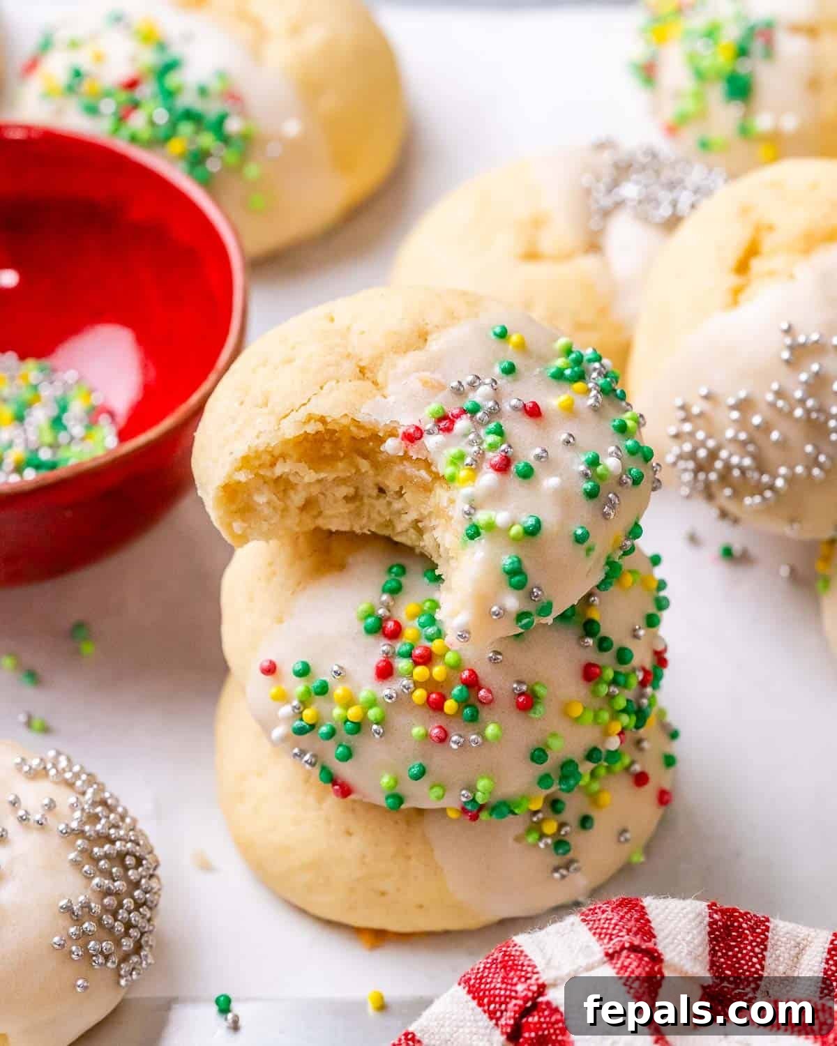 Sweet Italian Christmas Delights 7 A stack of three Italian Christmas Cookies, one with a bite taken out to reveal its soft interior, alongside whole cookies.