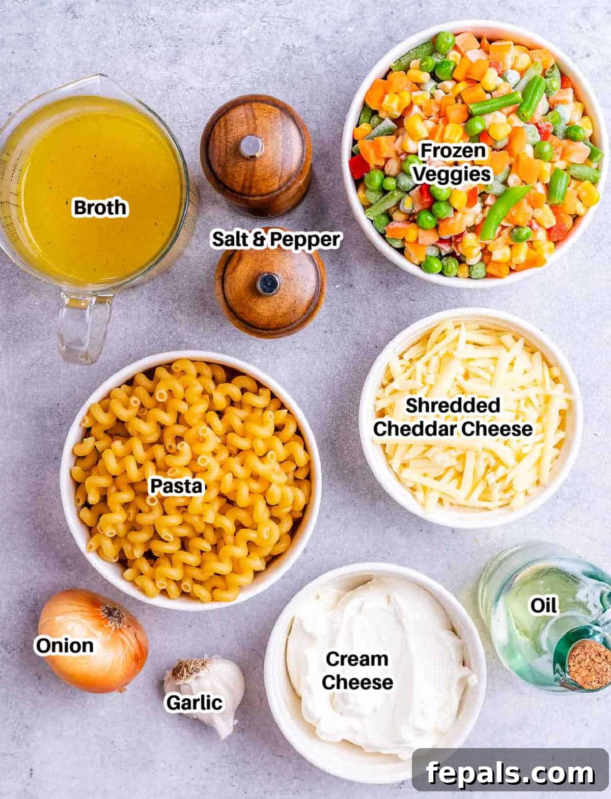 Vibrant Veggie Mac 3 A flat lay photograph showcasing all the ingredients required for making veggie mac and cheese, including pasta, cheese, broth, vegetables, and seasonings.