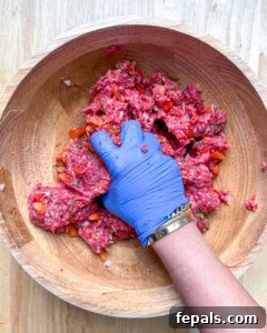 hand mixing the beef kebab mixture in a bowl.