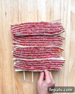inserting wooden skewers in the tortilla layered with beef.