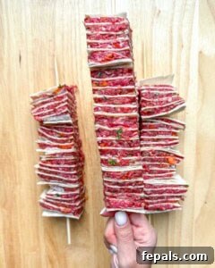 hand holding a single tortilla kebab.