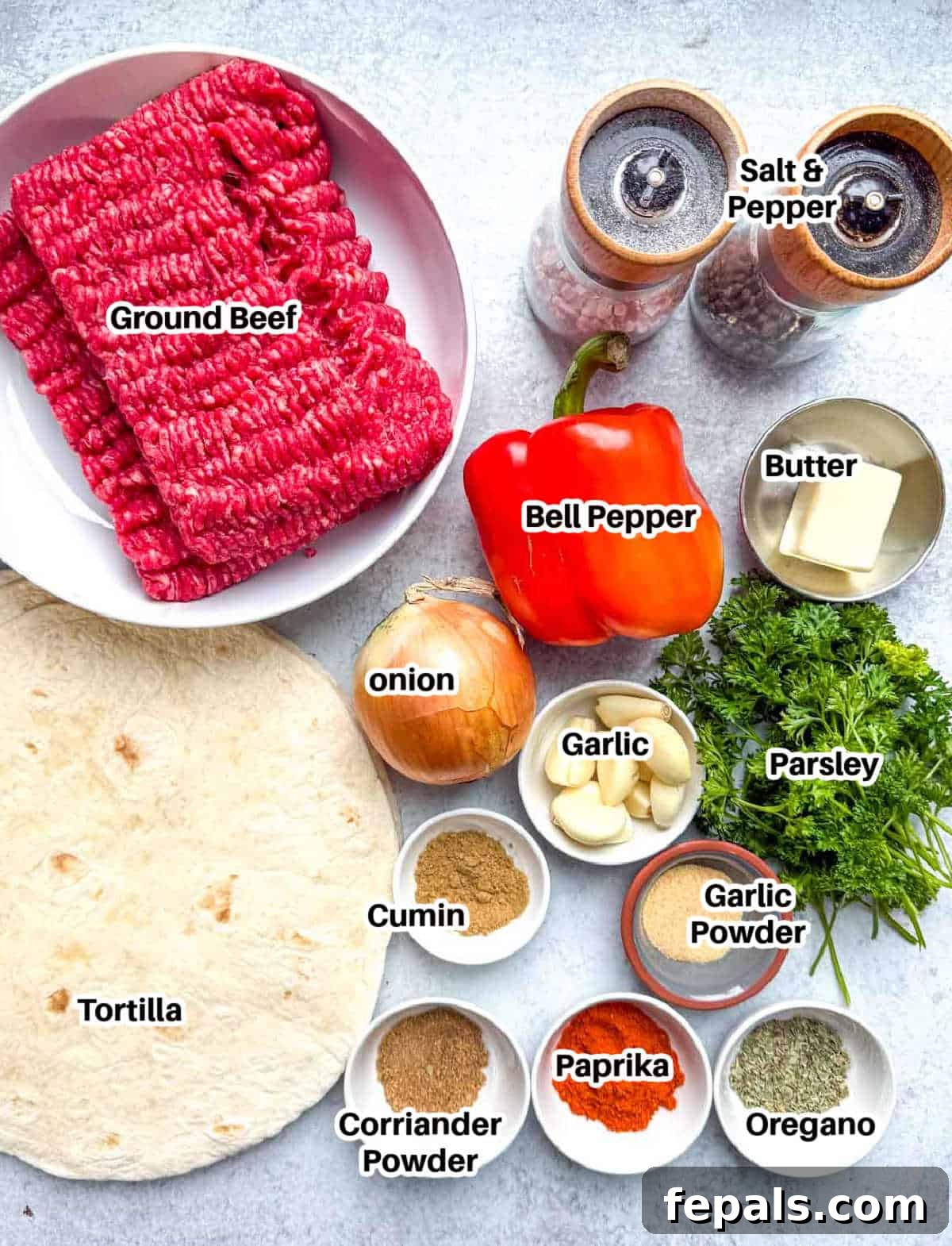 fresh ingredients laid out on a wooden board, including ground beef, tortillas, vegetables, and spices.