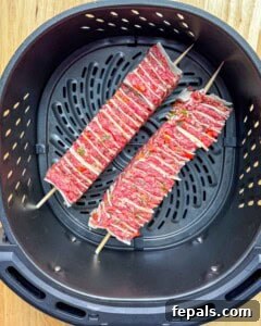two tortilla kebab skewers in the air fryer basket.