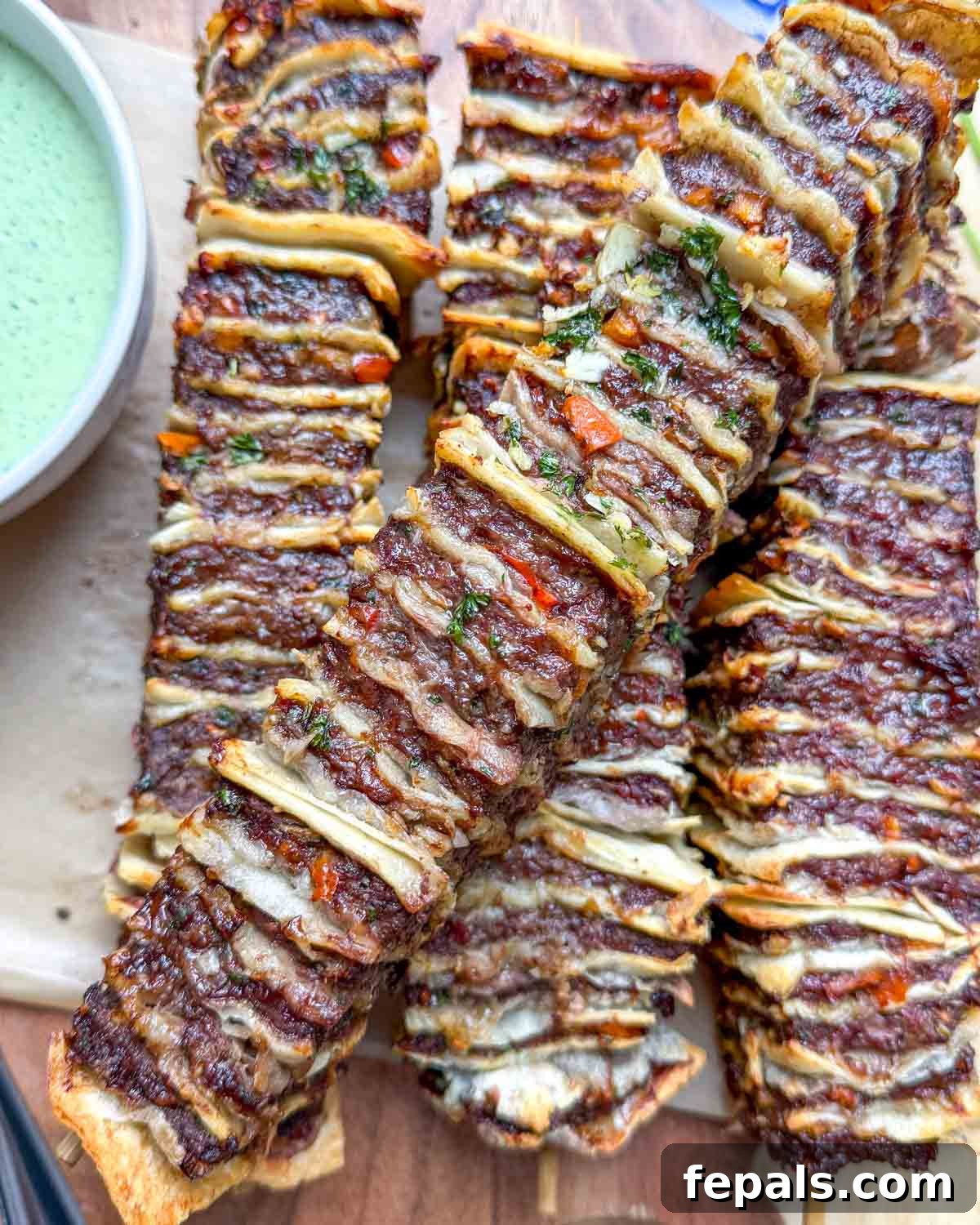 air fried tortilla kebabs stacked on a wooden board.