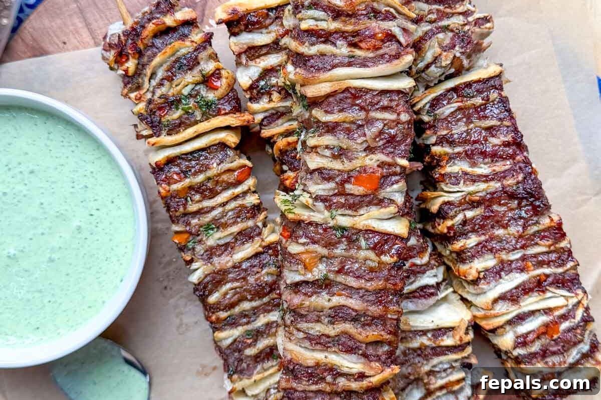 tortilla kebabs on a cutting board with yogurt dip on the side.