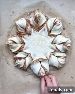 The process of forming a snowflake shape by twisting and joining puff pastry strands.