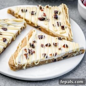 Three perfectly crafted Cranberry Bliss Bars arranged on a white plate.