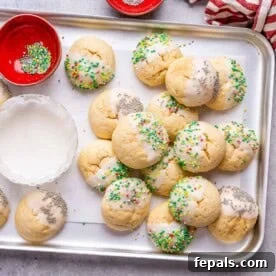 A baking sheet filled with freshly baked Italian Christmas Cookies, adorned with sprinkles.