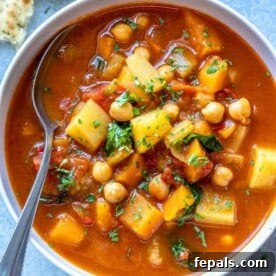 A cozy bowl of Moroccan vegetable soup with a spoon, ready to be enjoyed, highlighting its rich colors and textures.