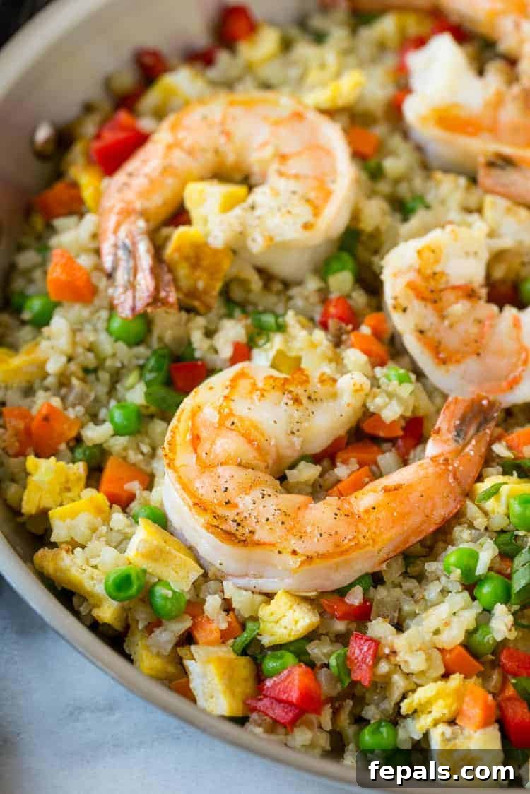 Healthy Shrimp Stir Fry with Vegetables: A Wholesome Meal Idea Shrimp cauliflower fried rice served beautifully on a plate, garnished with fresh green onions.