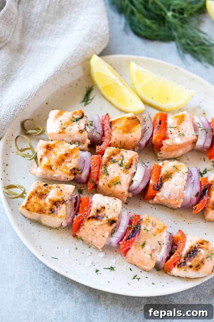 Three Dill salmon kabobs on a plate with fresh veggies, artfully arranged and ready to be enjoyed
