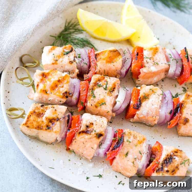 Top down shot of grilled salmon skewers on a plate with lemon, perfectly arranged for serving