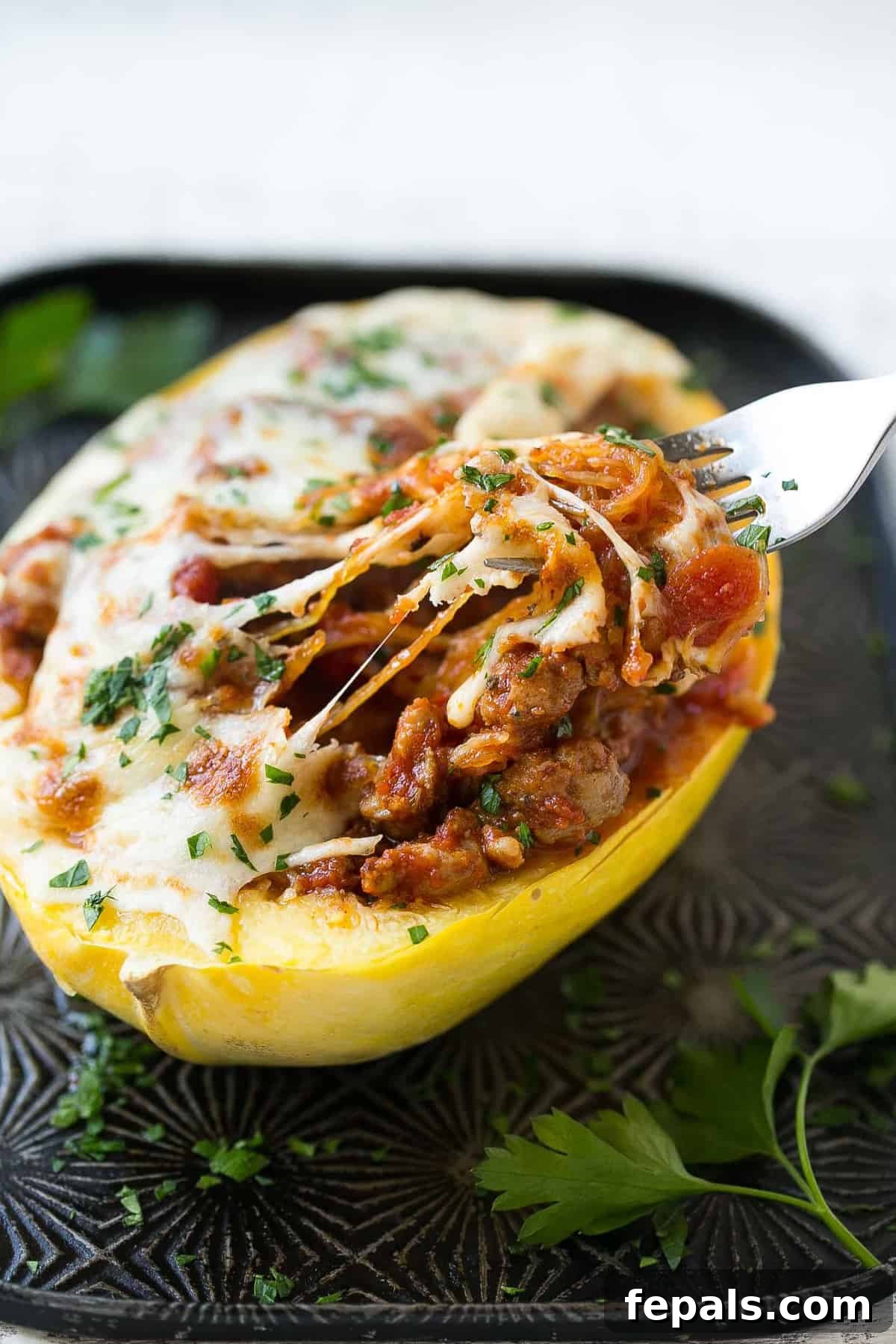 baked squash with fork grabbing bite, melted cheese