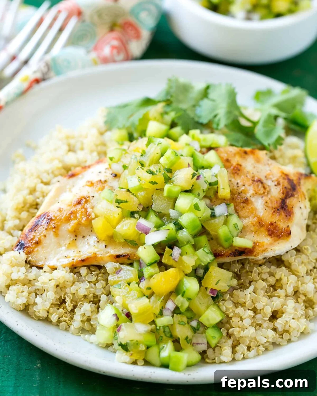 Mediterranean Grilled Chicken Quinoa 2 Juicy grilled chicken breast over fluffy quinoa, generously topped with a vibrant pineapple-cucumber salsa.
