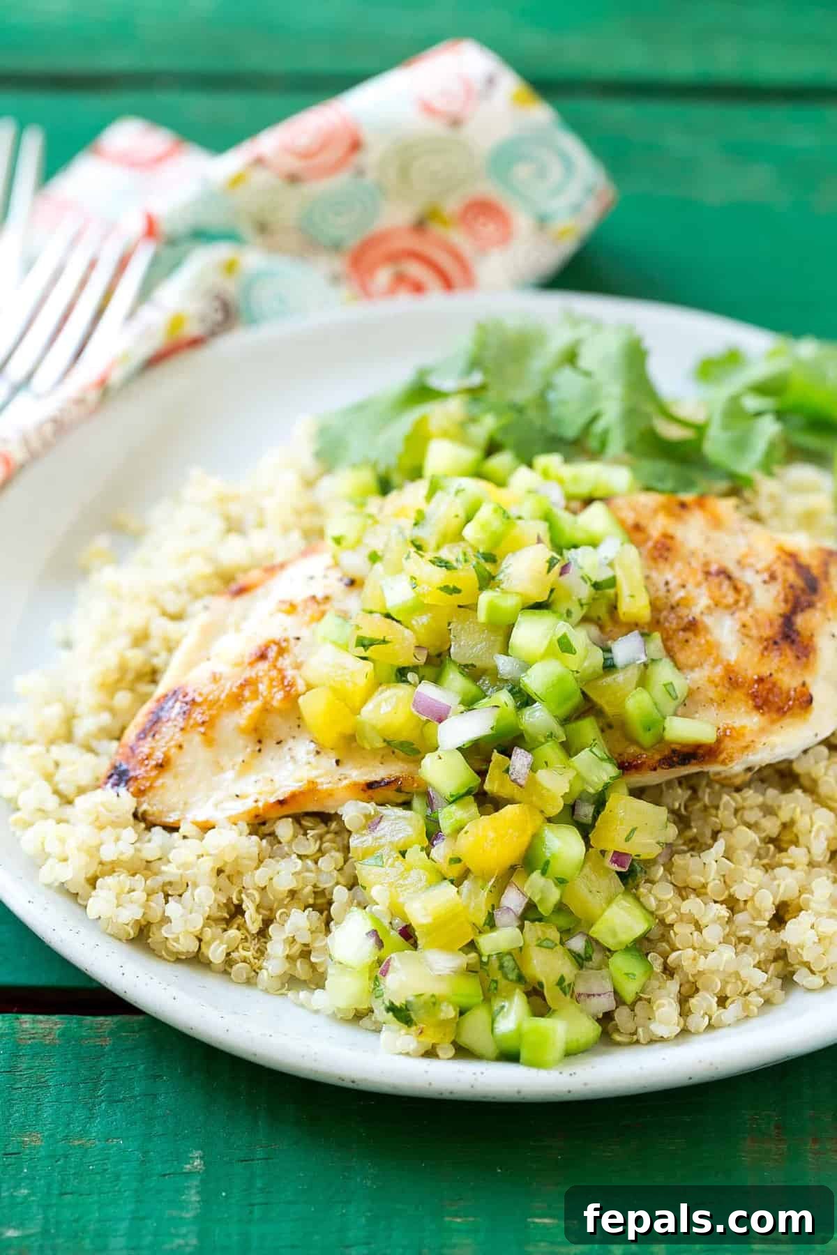 Mediterranean Grilled Chicken Quinoa 3 Plated grilled chicken topped with pineapple-cucumber salsa over quinoa, ready to be enjoyed.