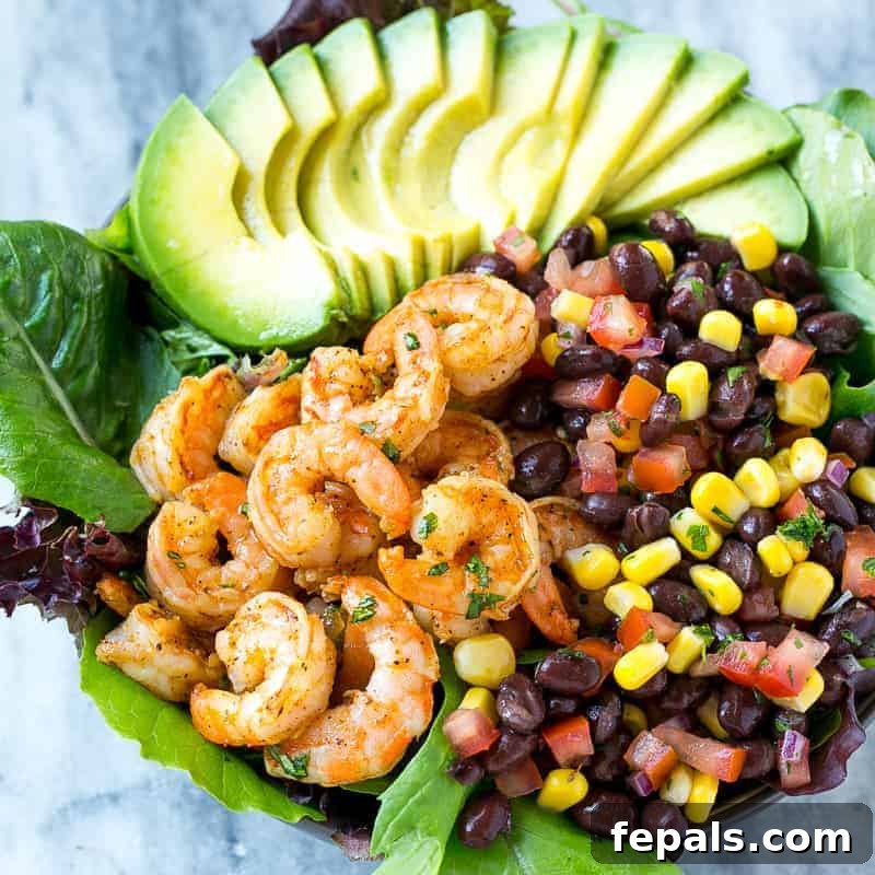 Overhead view of a prepared Mexican shrimp salad with fresh salsa, avocado, and chili-spiced shrimp, ready to serve.