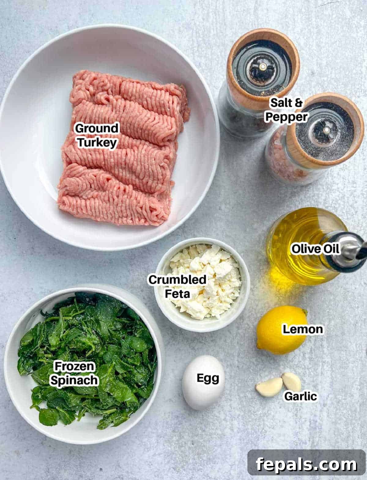 Gourmet Spinach and Feta Turkey Burgers 3 All ingredients laid out for making feta turkey burger patties: ground turkey, frozen spinach, feta cheese, garlic, egg, lemon, salt, and pepper.