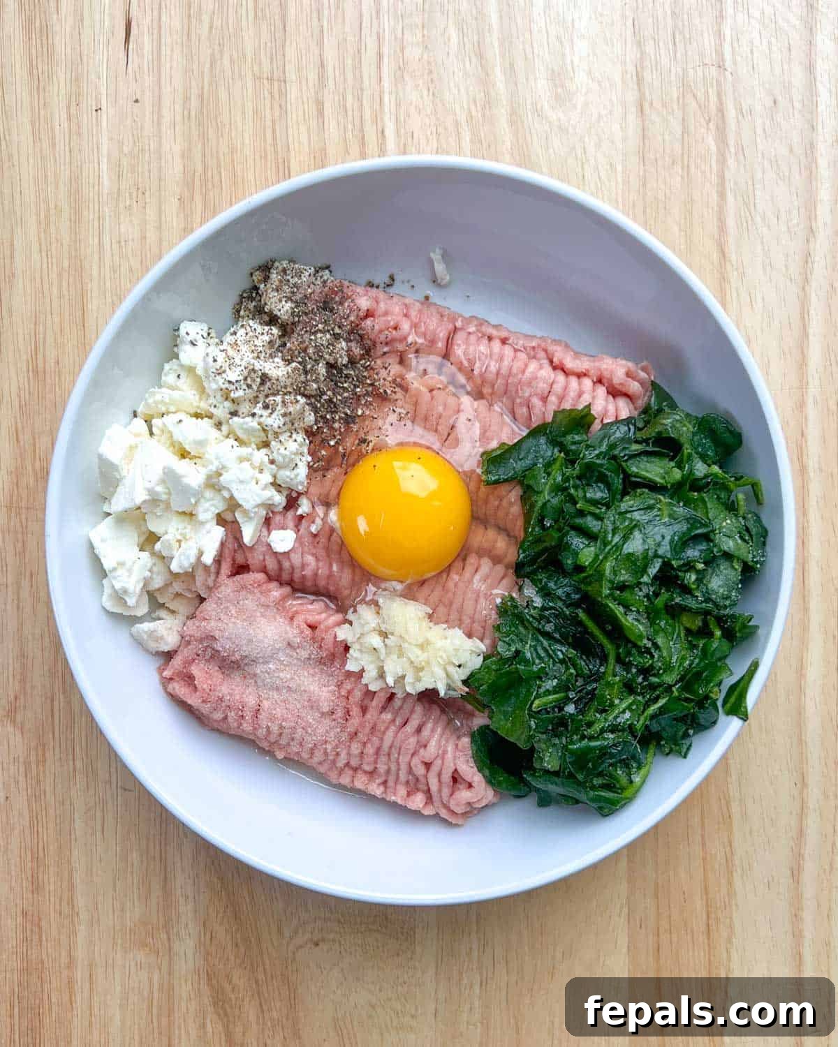 Gourmet Spinach and Feta Turkey Burgers 4 Ground turkey, thawed spinach, crumbled feta cheese, salt, pepper, minced garlic, egg, and lemon juice are combined in a large mixing bowl.