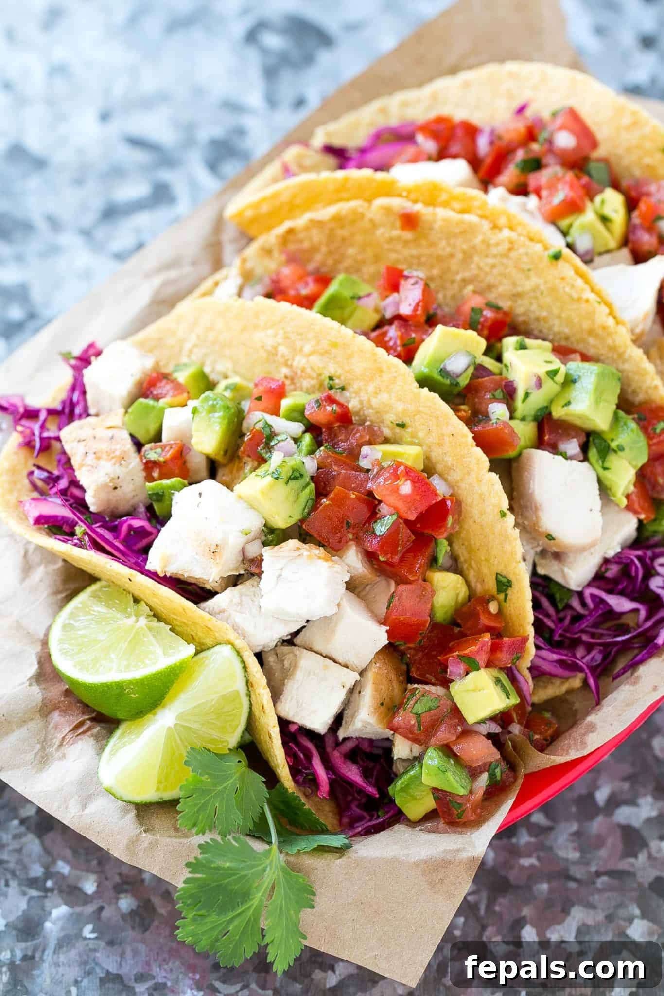 close up of Easy Chicken Tacos showing the chicken, slaw, and avocado salsa