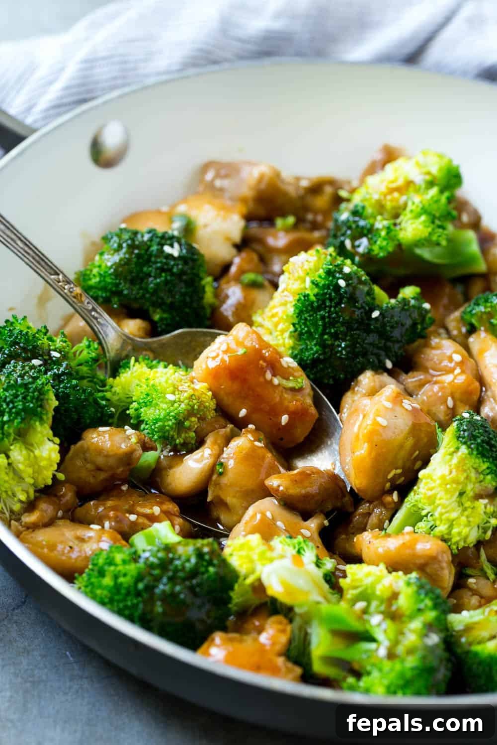 Healthy Chicken and Broccoli Stir-Fry in a Bowl Close-up of healthy chicken and broccoli stir-fry in a bowl, with a rich, glossy sauce and sprinkled with sesame seeds, showcasing its appetizing texture and flavor.