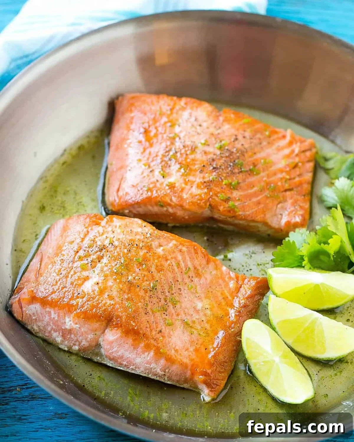 Sweet & Zesty Honey-Lime Salmon 4 Two succulent pan-seared salmon fillets in a cast iron skillet, garnished with fresh lime wedges, ready for the honey-lime glaze.