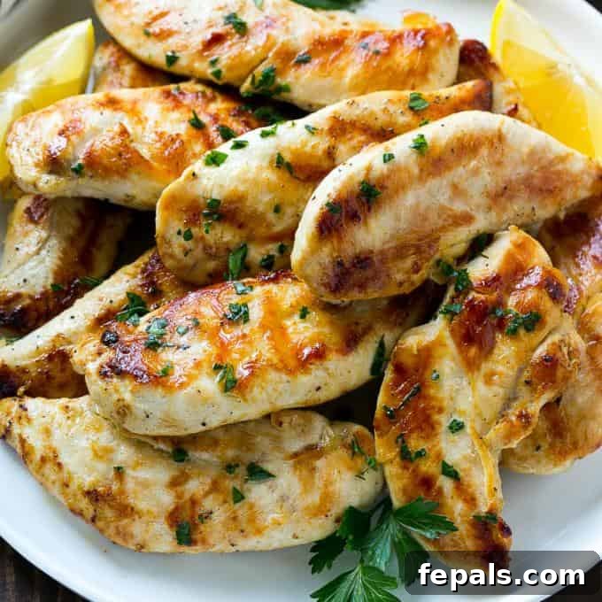 Zesty Lemon-Garlic Chicken Strips 4 Close-up of lemon garlic chicken tenders on a white plate, showcasing their perfectly cooked, golden-brown exterior and juicy texture.