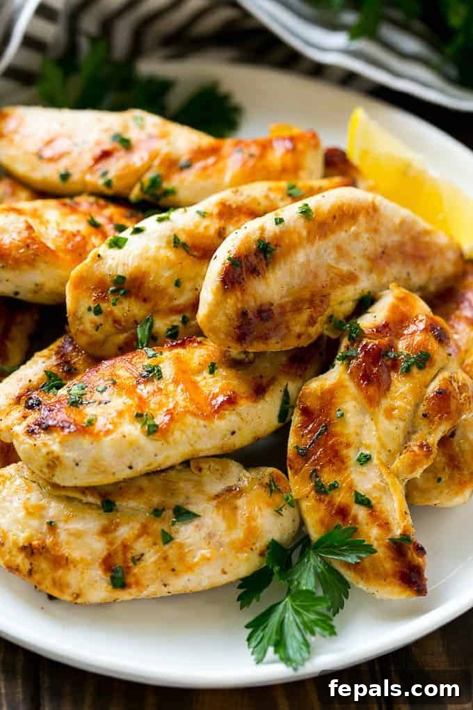 Zesty Lemon-Garlic Chicken Strips 5 Close-up shot of perfectly sauteed lemon garlic chicken tenders, golden brown and glistening, served on a pristine white plate, garnished with fresh herbs.