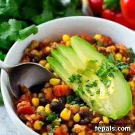 spoon in turkey chili recipe in a white bowl