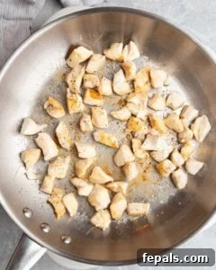 Seared chicken bites in a pan.