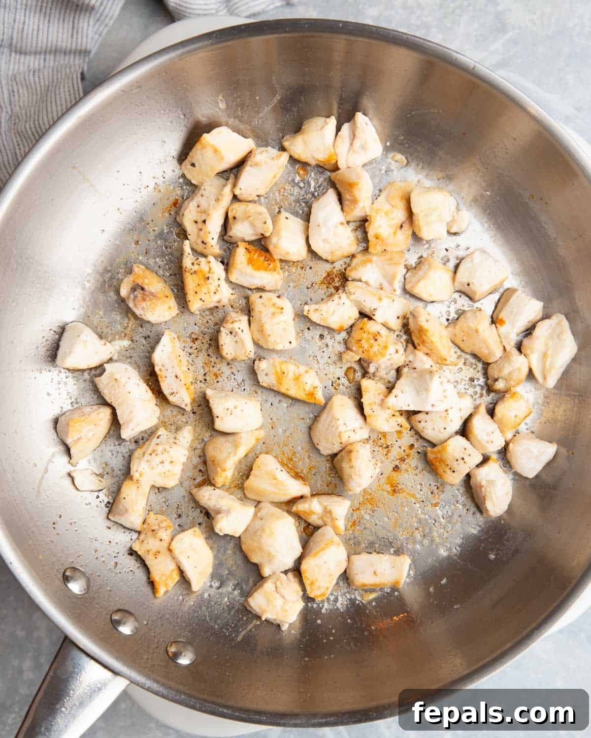 Classic Homemade Chicken Fried Rice 4 Perfectly seared chicken bites cooking in a hot skillet, developing a golden-brown crust.