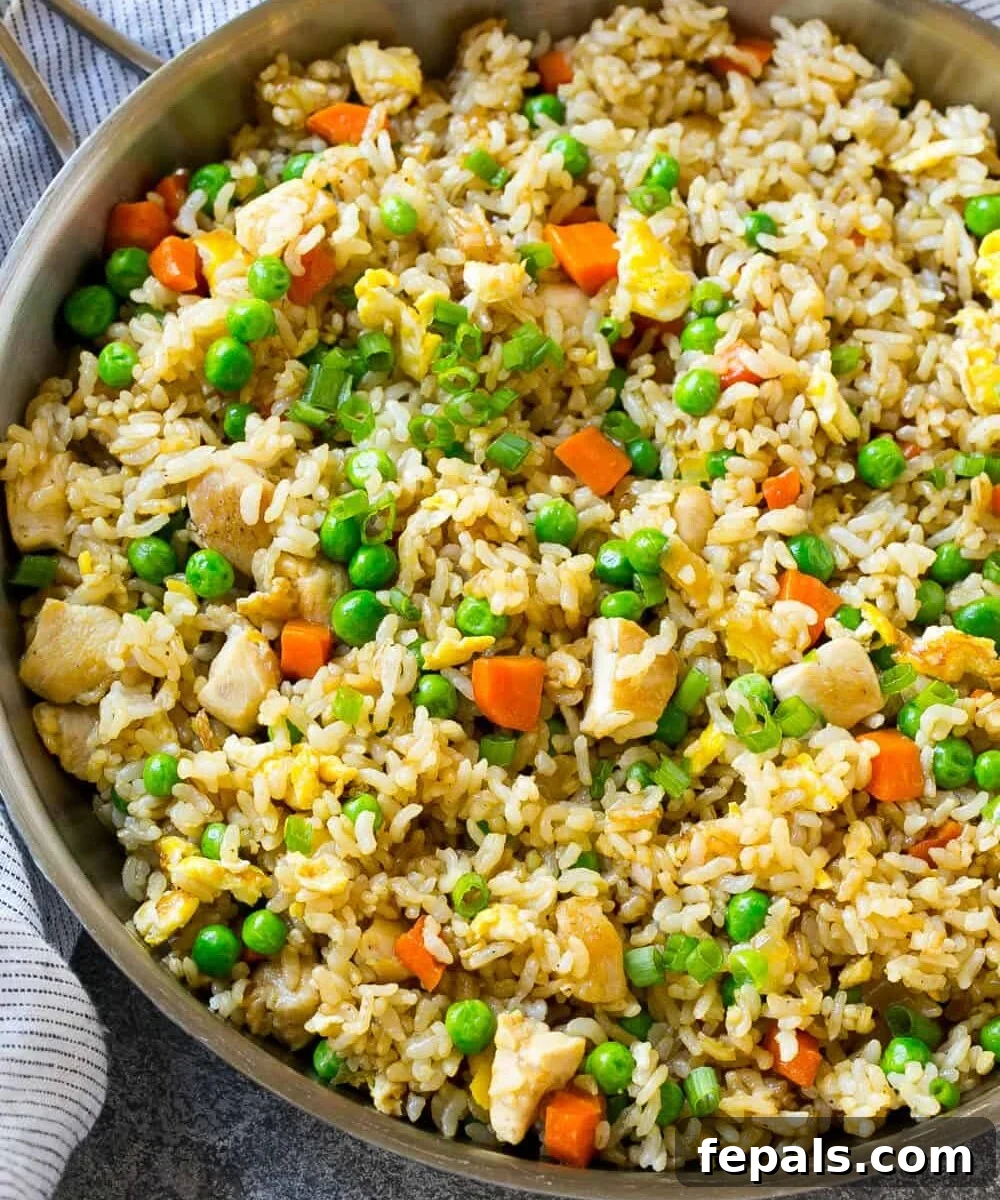 Classic Homemade Chicken Fried Rice 8 A large skillet filled with freshly made chicken fried rice, garnished with green onions and ready for serving.
